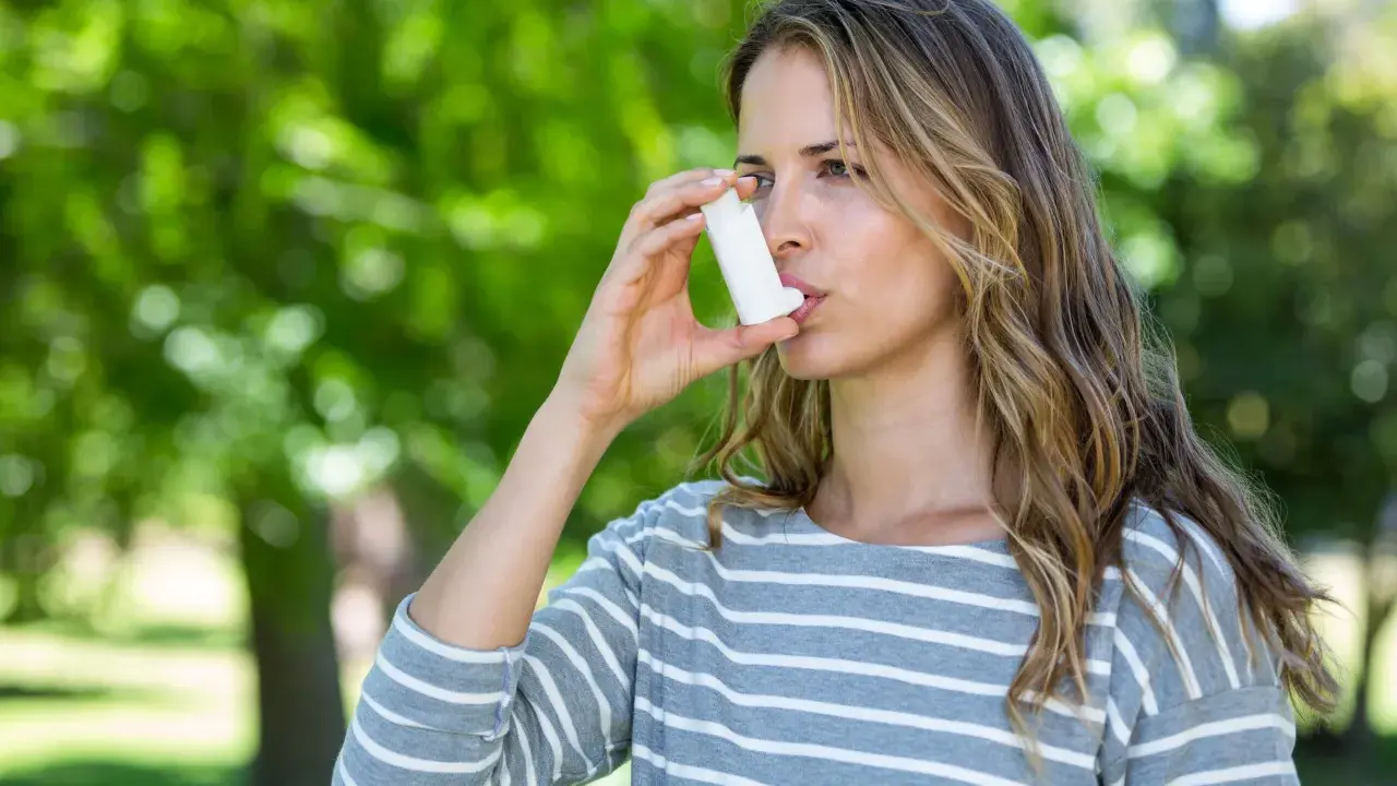 Frau mit Inhalator im Freien. Bei Asthma kann die richtige Dosierung von Prednisolon Tabletten wichtig sein.