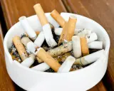 A full Aschenbecher mit Zigarettenstummeln. Vielleicht ein Hinweis auf die Champix-Nebenwirkungen, die das Rauchen erschweren.